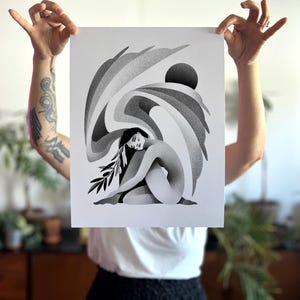 May include: A white ceramic mug with a black handle and the text "But First, Coffee" in a bold, black font. The mug is set against a blurred background, highlighting its simple design.