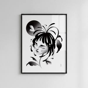 May include: A black and white framed art print featuring a stylized illustration of a person with closed eyes, surrounded by flowing hair and botanical elements. A dark circular shape sits in the upper left corner, and the artwork is enclosed in a thin black frame.