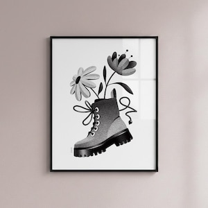 May include: Black and white framed art print featuring a combat boot with flowers. The boot is gray with black accents and laces, and the flowers are stylized. The artwork is a monochromatic illustration.