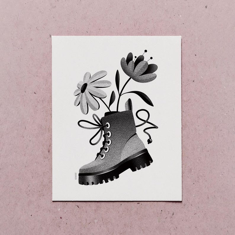 May include: Black and white illustration of a combat boot filled with flowers. The boot has a thick sole, laces, and a loop at the top. Two flowers, one daisy-like and one more structured, emerge from the boot.