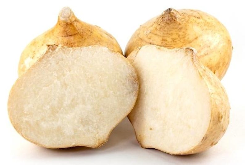 Pu&ograve; includere: Due tuberi di jicama interi con buccia color marrone chiaro e due met&agrave; di jicama che mostrano una polpa interna bianca, umida e croccante. Gli ortaggi presentano una forma arrotondata e leggermente appiattita con una piccola punta.
