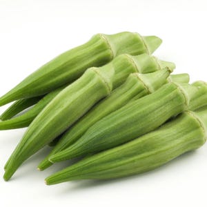 May include: A cluster of fresh, vibrant green okra pods arranged together. Each pod features a tapered, elongated shape with a slightly ridged, fibrous texture and a pointed tip, showcasing the natural light green color of the vegetable.