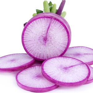 Puede incluir: Un r&aacute;bano daikon morado en rodajas que muestra un anillo exterior magenta vibrante y un interior blanco p&aacute;lido y transl&uacute;cido con un patr&oacute;n radial. La verdura presenta una secci&oacute;n transversal circular gruesa y varias rodajas redondas m&aacute;s finas.