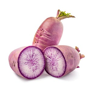 Puede incluir: Un r&aacute;bano daikon morado entero colocado detr&aacute;s de dos mitades de un r&aacute;bano daikon morado cortado. La piel exterior es de un vibrante color magenta-morado, mientras que la pulpa interior es blanca con un patr&oacute;n radiante de manchas y vetas moradas.