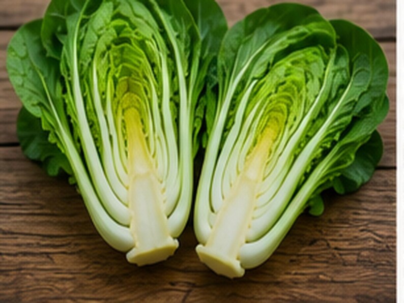 Puede incluir: Dos mitades de una verdura bok choy fresca que muestran su estructura interna. La planta presenta tallos gruesos, blancos y suculentos que se transforman en hojas anchas de color verde vibrante. La secci&oacute;n transversal revela la disposici&oacute;n densa.