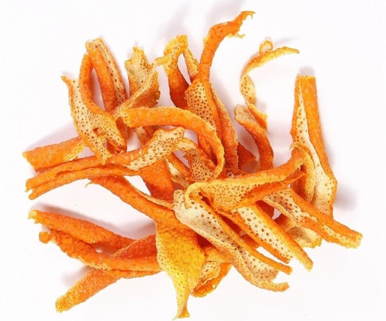 May include: A collection of dried orange peel strips, featuring a vibrant orange exterior with a textured, porous surface and a pale, off-white fibrous interior. The pieces are irregularly shaped, curled, and twisted into various lengths.
