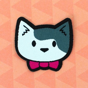 May include: A white and grey cat head with a pink bow tie. The cat is wearing a bow tie. The cat is looking to the right. The background is a peach colour with a geometric pattern.