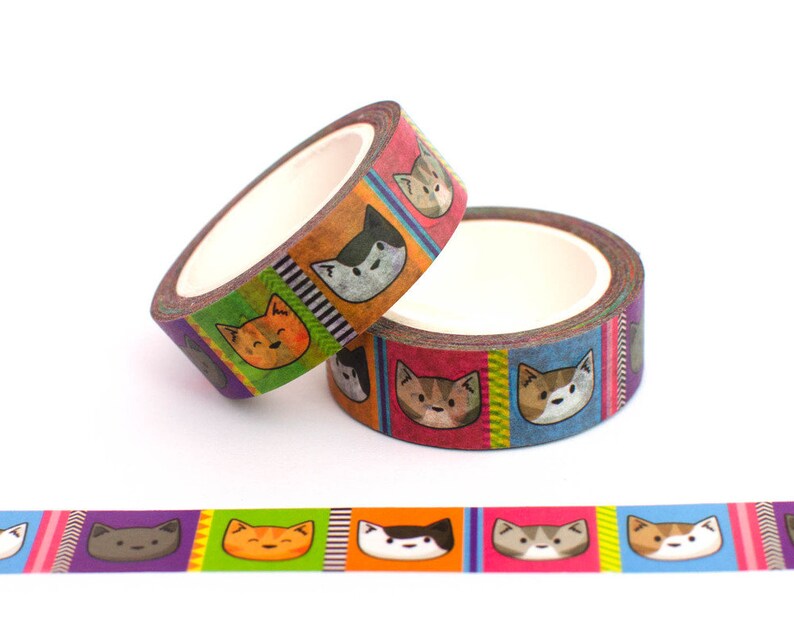 May include: Two rolls of colorful washi tape with a repeating pattern of cartoon cats. The tape is red, orange, yellow, green, blue, and purple. The cats are different colors and have different expressions.