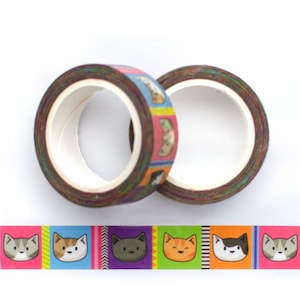 May include: Two rolls of colorful washi tape with a repeating pattern of cartoon cats. The tape is brown with a rainbow colored background and features different colored cats with different expressions.