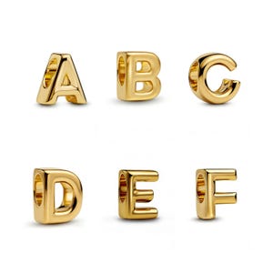 Op de afbeelding: Zes goudkleurige alfabetbedels, waaronder de letters A, B, C, D, E en F. Elke bedel is een driedimensionaal ontwerp met een gat om te rijgen. De letters zijn in een schreefloze lettertype.