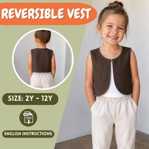 May include: A dark brown sleeveless vest with a rounded front opening, worn over a white top and light-colored trousers. The image includes the text REVERSIBLE VEST, SIZE: 2Y - 12Y, and ENGLISH INSTRUCTIONS, along with a circular inset view.