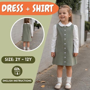 May include: A young girl wearing a green dress over a white long-sleeved shirt with a white collar. The dress has a button-up front. The image includes the text "DRESS + SHIRT", "SIZE: 2Y - 12Y", and "ENGLISH INSTRUCTIONS".