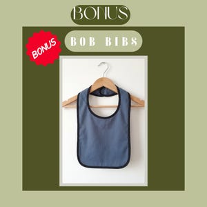 Pode incluir: Um babete azul com acabamento preto pendurado num cabide de madeira. O babete &eacute; de cor lisa com decote arredondado. A imagem inclui o texto "BONUS" e "BOB BIBS". Existe tamb&eacute;m uma forma de estrela vermelha com a palavra "BONUS".
