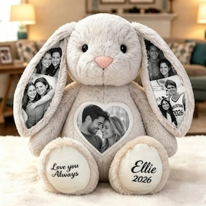 May include: A plush beige rabbit stuffed animal featuring black and white photo prints on its long ears and a heart-shaped patch on its chest. The rabbit's feet have white fabric patches with the text Love you Always and Ellie 2026 printed.
