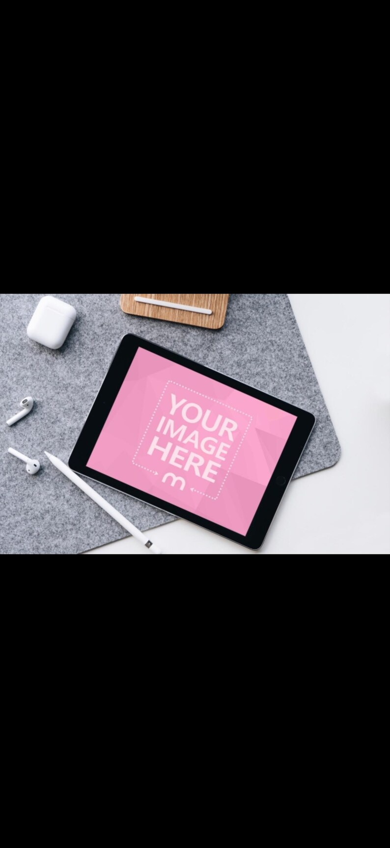 Op de afbeelding: Een digitale tablet met een roze scherm met de tekst "YOUR IMAGE HERE" en een stylus. De tablet ligt op een grijze viltachtige ondergrond, met witte draadloze oordopjes en een oplaadcase in de buurt.