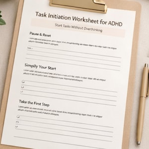 Könnte beinhalten: Ein Klemmbrett mit einem Arbeitsblatt mit dem Titel "Task Initiation Worksheet for ADHD" und dem Untertitel "Start Tasks Without Overthinking". Ein Stift und eine Tasse sind ebenfalls sichtbar.