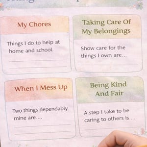 May include: A colorful worksheet titled "Things I'm Responsible For" with sections for chores, belongings, mistakes, and kindness. A hand holding a pencil is writing on the worksheet. Decorative elements include a rainbow, bear, and star-shaped stickers.