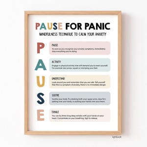 Op de afbeelding: Een ingelijste print met de tekst "PAUSE FOR PANIC" en een mindfulness techniek om angst te kalmeren. De poster geeft stappen weer: Pauze, Activiteit, Begrijpen, Kalmeren en Uitademen. De print zit in een houten lijst.