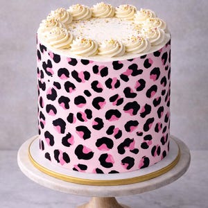 Può includere: Torta rotonda con glassa rosa con stampa leopardata. La torta è sormontata da riccioli di crema al burro bianca e zuccherini. Si trova su un alzatina bianca e dorata, ideale per una festa o un'occasione speciale.