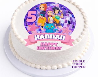 May include: A round white cake with white frosting and a decorative border. The cake features a colorful edible image with the name "Hannah" and the words "Happy Birthday". The image includes cartoon characters, a blue cat, and the number 5.