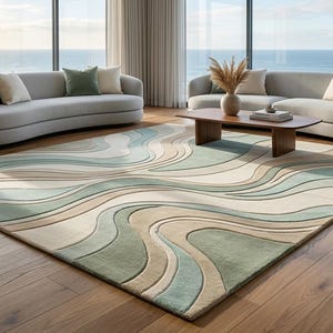 Könnte beinhalten: Ein rechteckiger Teppich mit einem geschichteten, wellenförmigen Muster in Salbeigrün, Creme und Beige. Das Design besteht aus glatten, fließenden Linien, die eine Tiefe und Bewegung auf der Oberfläche des Bodenbelags erzeugen.