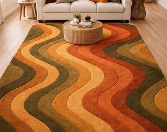 May include: A large, retro-style area rug with a wavy pattern in shades of orange, yellow, and green. The rug is the focal point of a living room, complementing the neutral-toned furniture and decor. The rug's dimensions are approximately 8 x 10 feet.