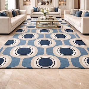 Puede incluir: Una alfombra grande y estampada con un diseño moderno de mediados de siglo. La alfombra presenta un patrón repetitivo de círculos y óvalos azules, beige y blancos. La alfombra está colocada en una sala de estar con sofás color crema y una lámpara de araña dorada.