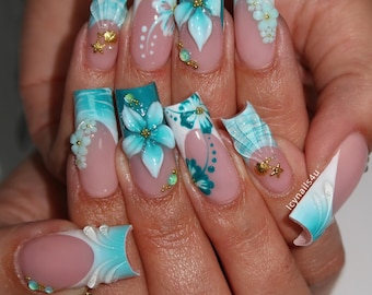 May include: Long, square-shaped acrylic nails with a French tip design. The nails feature a light pink base with turquoise and white accents, 3D flower and seashell designs, and gold embellishments. The text "icynails4u" is visible on one nail.