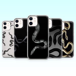 Könnte beinhalten: Eine Sammlung von fünf Handyhüllen mit Schlangenmotiven. Die Hüllen zeigen verschiedene Schlangenillustrationen in Schwarz, Weiß und Gold auf schwarzen und weißen Hintergründen. Die Designs umfassen detaillierte Schlangenmuster und -silhouetten.