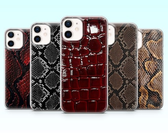 May include: A collection of five smartphone cases with various reptile skin patterns. The cases feature a range of colors, including red, black, brown, and tan. The designs mimic the textures of snake and crocodile skin.