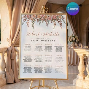 May include: A rectangular wedding seating chart sign in a gold frame on a gold easel. The sign features a watercolour floral header, the text Robert + Michelle, September 25, 20XX, Find Your Seat, and a list of twelve tables with guest names.