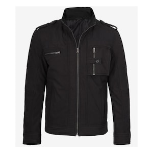 Puede incluir: Chaqueta negra con cuello alzado y cierre de cremallera. La chaqueta tiene múltiples bolsillos, incluyendo dos bolsillos en el pecho con cremallera y dos bolsillos laterales. Los hombros tienen charreteras. La chaqueta está hecha de un material duradero.