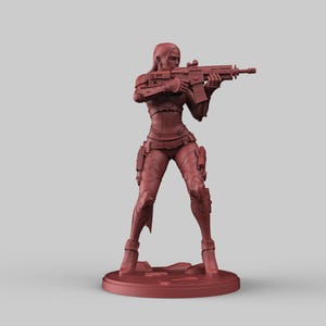 May include: A red-brown figurine of a person holding a rifle, posed in a shooting stance. The figure is wearing a form-fitting outfit with tactical gear. The figurine is standing on a circular base.