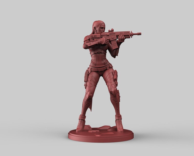 May include: A red-brown figurine of a person holding a rifle, posed in a shooting stance. The figure is wearing a form-fitting outfit with tactical gear. The figurine is standing on a circular base.