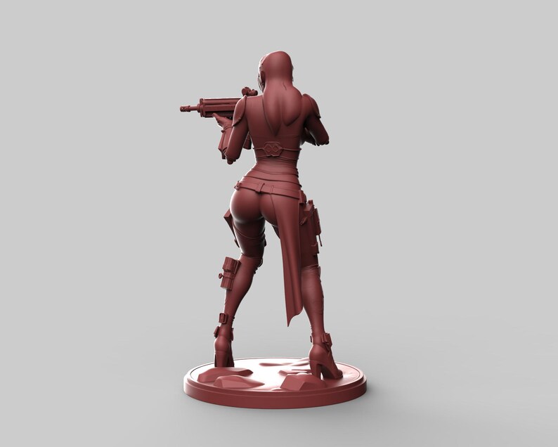 May include: A maroon-colored figurine of a female character in a combat outfit, holding a rifle. The figure is standing on a circular base. The character is wearing a fitted top, pants, and boots.
