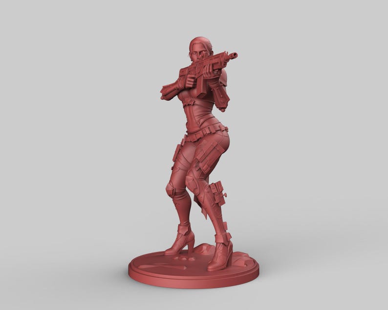 May include: A red-brown figurine of a female character in a combat pose, holding a rifle. The figure is wearing armor and high-heeled boots, standing on a circular base. The overall design suggests a science fiction or fantasy theme.