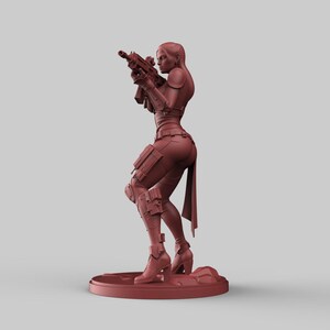 May include: A reddish-brown figurine of a person aiming a rifle. The figure is wearing tactical gear, including a vest, knee pads, and boots. The figurine is standing on a circular base.