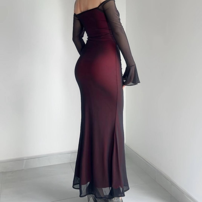 May include: A floor-length, off-the-shoulder gown featuring a deep burgundy bodice layered under a sheer black mesh overlay. The dress includes long, flared sleeves made of translucent black fabric, creating a dark, layered appearance.