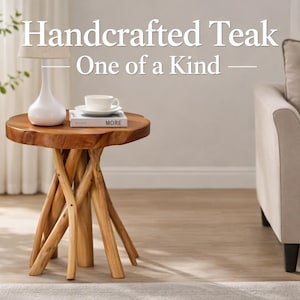 Puede incluir: Mesa auxiliar de teca artesanal con acabado de madera natural. La mesa presenta una tapa redonda y una base única hecha de vigas de madera entrelazadas. Una lámpara blanca, un libro y una taza de té están sobre la mesa. El diámetro es de unos 61 cm.
