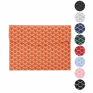 May include: An orange envelope-style clutch with a repeating geometric pattern. The clutch has a flap closure and is shown with a color palette of additional options, including navy, white, and red.