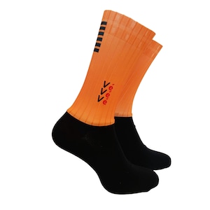May include: A pair of athletic socks. The uppers are orange, and the foot sections are black. The orange section has black stripes and the word "eee" with arrows in red. The socks have a ribbed design.
