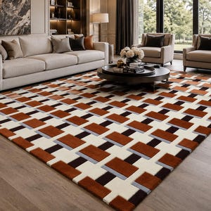 May include: A rectangular area rug featuring a geometric pattern of interlocking blocks in shades of burnt orange, dark brown, cream, and light gray. The design consists of repeating rectangular shapes arranged in a structured, grid-like layout.