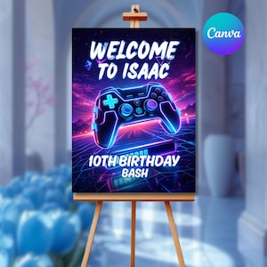 May include: A wooden easel displays a vibrant sign with the text "WELCOME TO ISAAC" and "10TH BIRTHDAY BASH." A neon blue and purple video game controller is the central graphic. The Canva logo is in the upper right corner.