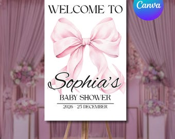 Könnte beinhalten: Ein Willkommensschild für Sophias Babyparty mit einer großen rosa Schleifenillustration. Das Schild enthält den Text "Willkommen zu Sophias Babyparty" und das Datum "2026 - 25. Dezember". Das Schild wird auf einer Holzstaffelei angezeigt.
