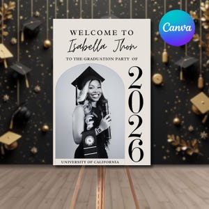 Könnte beinhalten: Willkommensschild für eine Abschlussfeier mit einem Schwarz-Weiß-Foto einer Absolventin in Hut und Robe. Auf dem Schild steht "Willkommen bei Isabella Thon" und "2026" mit dem Logo der University of California.