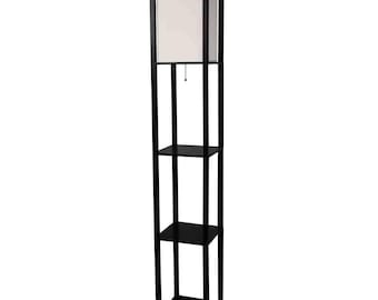 May include: A tall, square floor lamp featuring a dark brown wooden frame with three integrated storage shelves. The top section contains a white, rectangular fabric lampshade with a small pull-chain switch hanging from the center.
