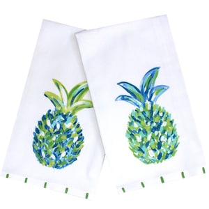 Op de afbeelding: Twee witte keukendoeken met een groen en blauw ananasontwerp. De ananas zijn geschilderd in aquarelstijl.