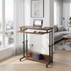 May include: A brown and black adjustable laptop desk with a pull-out keyboard tray. The desk has a metal frame and sits on rolling wheels. A laptop, keyboard, and mouse are on the desk. Two blue boxes are on the bottom shelf.