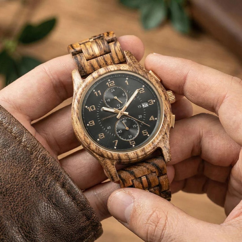 Hand holding personalized wooden watch for men, front facing handmade zebrawood wrist watch gift