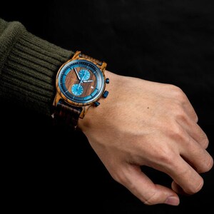 Personalized engraved wooden watch for men zebrawood blue dial front view wearing on hand